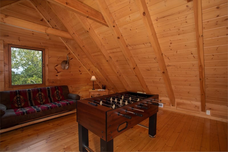 Foosball table and a futon in the loft at Cedar Creeks, a 2bedroom cabin rental located near Douglas Lake