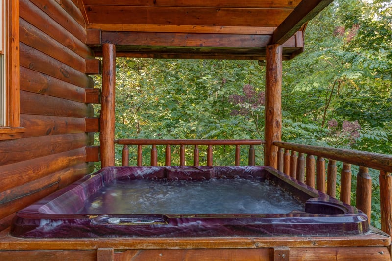 Hot tub on a covered deck at Lincoln Logs, a 2 bedroom cabin rental located in Gatlinburg