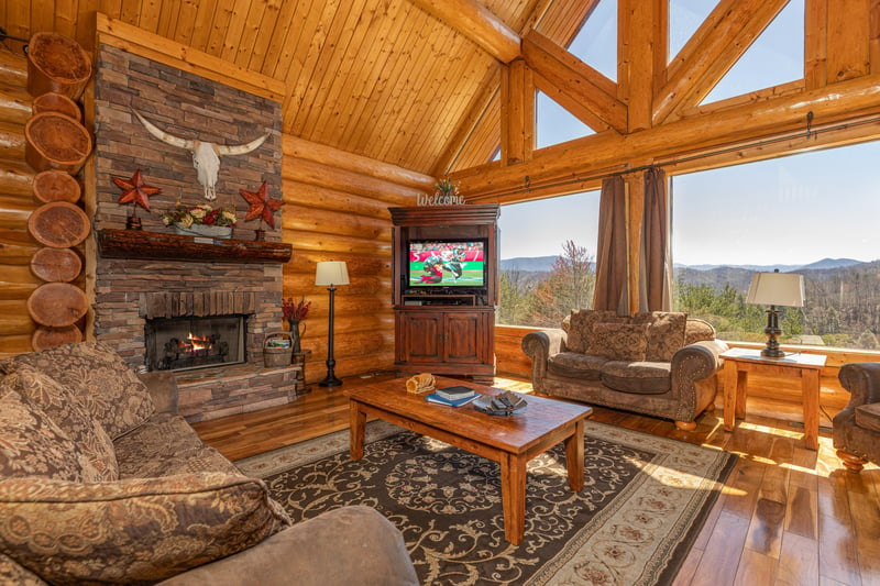 Living room with fireplace, TV, and mountain views at Gods Country, a 4 bedroom cabin rental located in Pigeon Forge