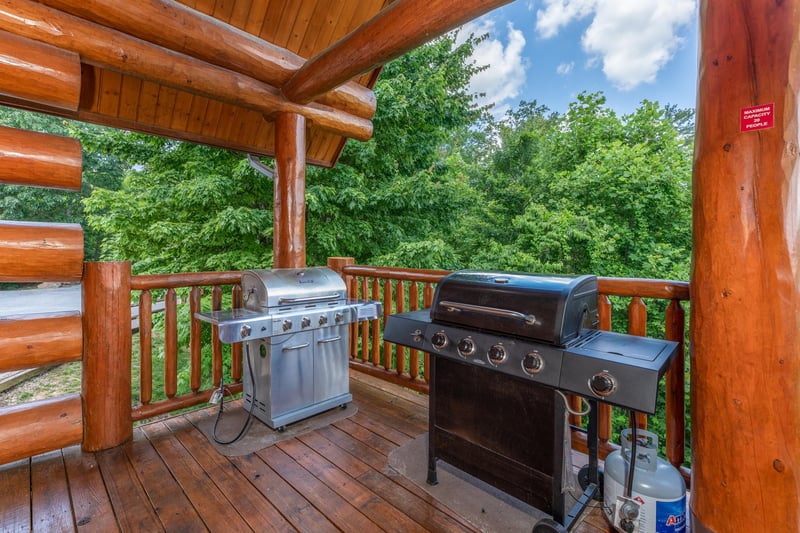 Two propane grills on a covered deck at Gods Country, a 4 bedroom cabin rental located in Pigeon Forge