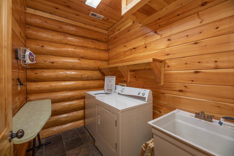 Laundry space with an iron and ironing board, washer and dryer, and utility sink at Gods Country, a 4 bedroom cabin rental located in Pigeon Forge