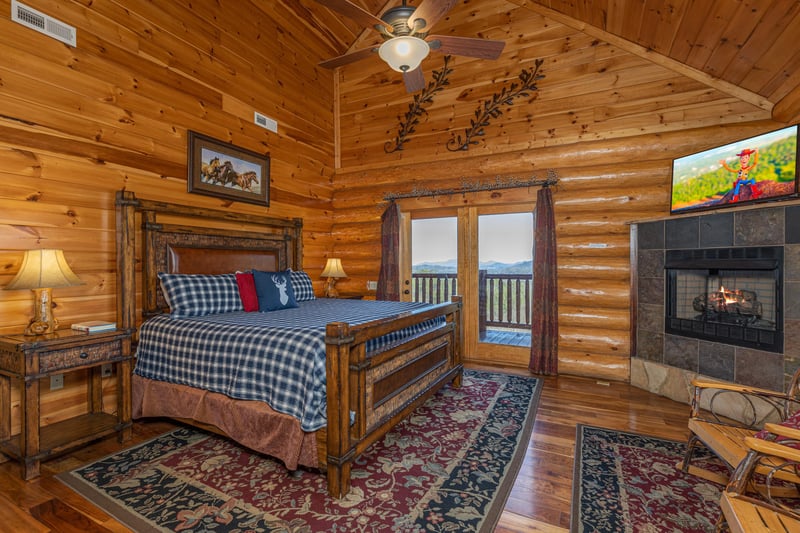 Bedroom with king bed, fireplace, tv, and deck access at Gods Country, a 4 bedroom cabin rental located in Pigeon Forge