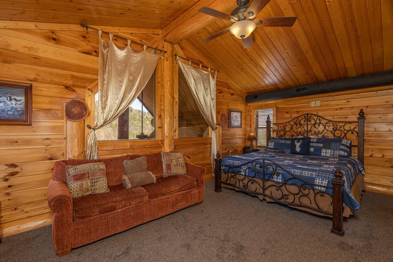 Loft bedroom with a king bed and sofa at Gods Country, a 4 bedroom cabin rental located in Pigeon Forge