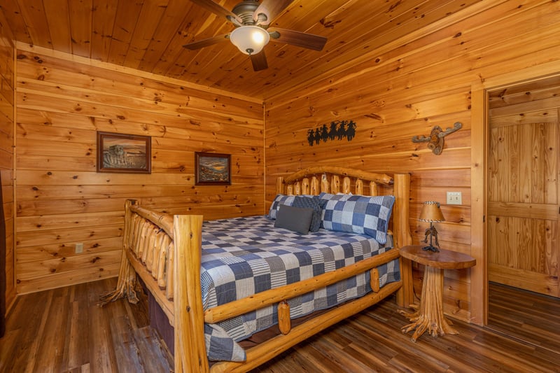 Bedroom with a log bed and night stand at Gods Country, a 4 bedroom cabin rental located in Pigeon Forge