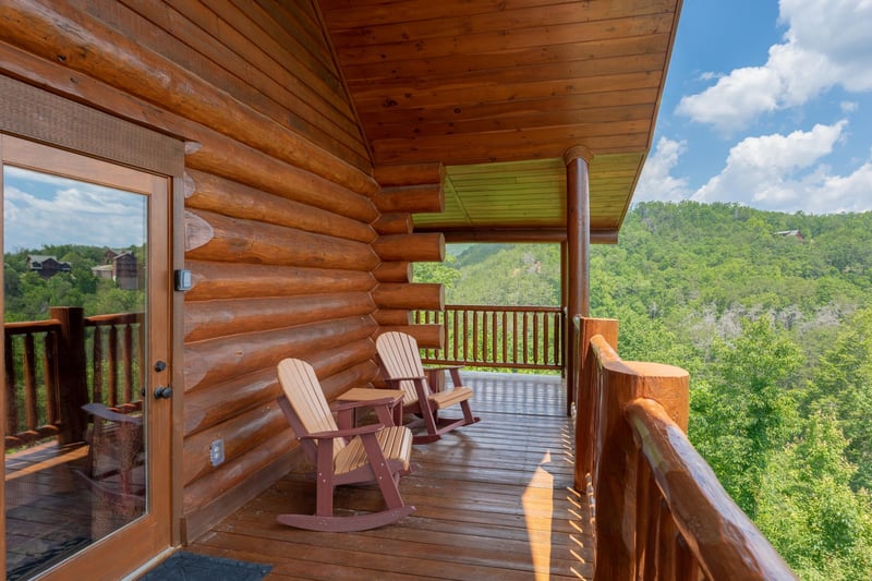 Rocking chairs on a covered deck at Gods Country, a 4 bedroom cabin rental located in Pigeon Forge