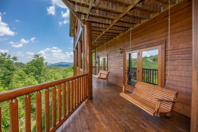 Swings on a covered deck at Gods Country, a 4 bedroom cabin rental located in Pigeon Forge