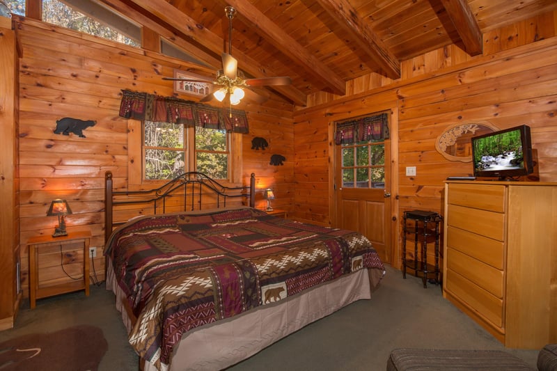 Bedroom with night stands, lamps, dresser, and TV at Hawks Nest, a 1 bedroom cabin rental located in Pigeon Forge