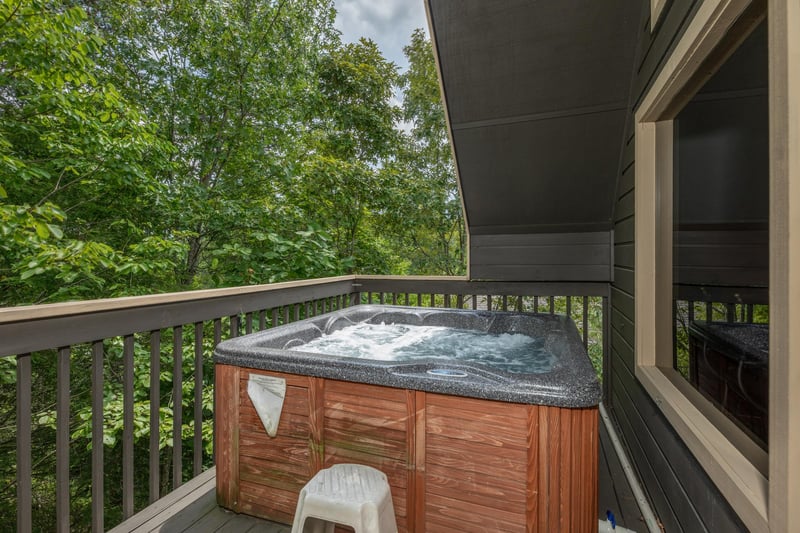 Hot tub on a semicovered deck at Amazing Memories, a 3 bedroom cabin rental located in Pigeon Forge