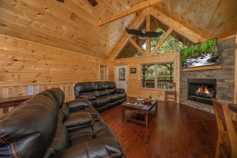 Sofa, loveseat, fireplace, and tv in a living room at Gar Bears Hideaway, a 3 bedroom cabin rental located in Pigeon Forge