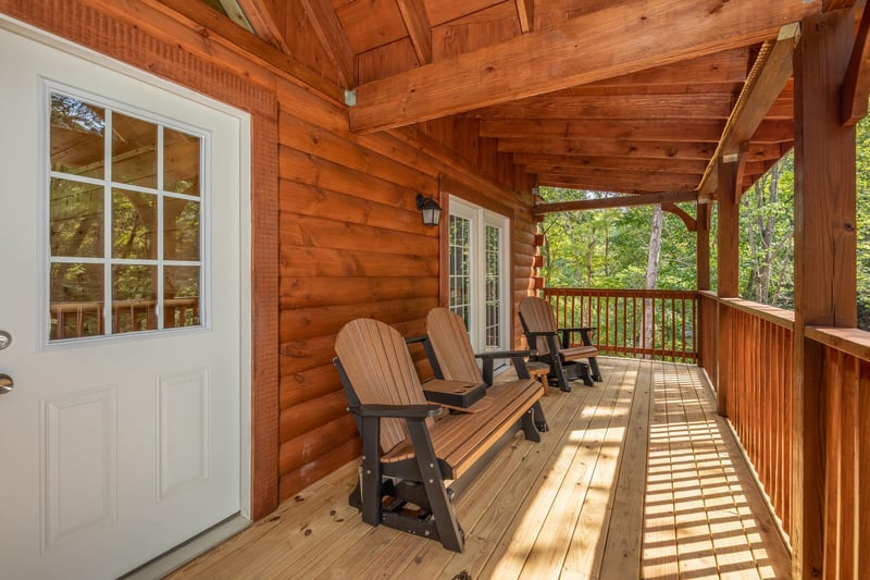 Adirondack chairs and bench on a deck at Gar Bears Hideaway, a 3 bedroom cabin rental located in Pigeon Forge