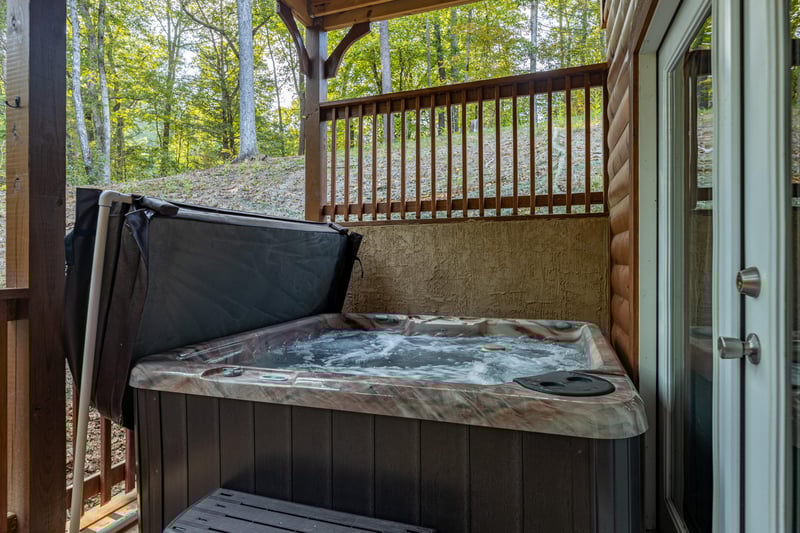 Hot tub on a covered deck at Gar Bears Hideaway, a Pigeon Forge cabin rental