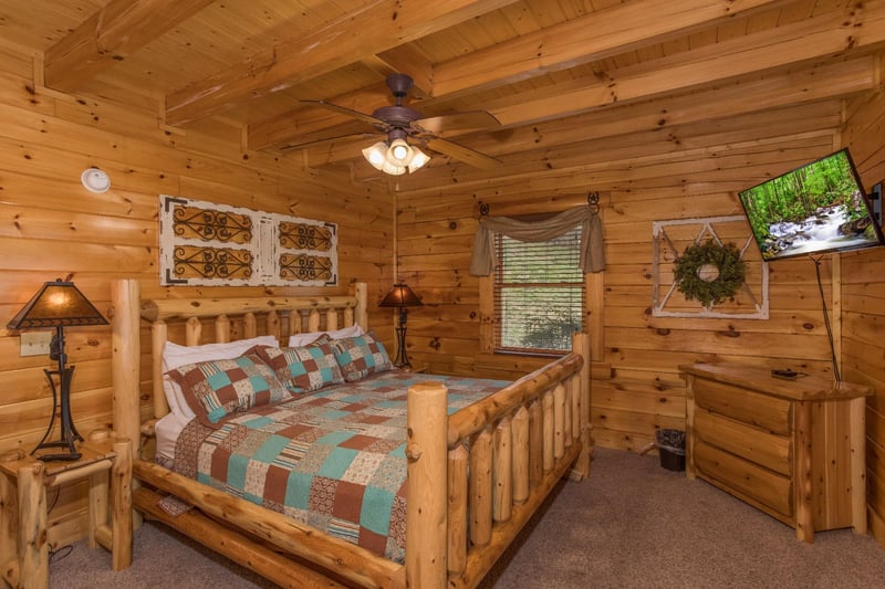 Bedroom with a king sized bed, dresser, and television