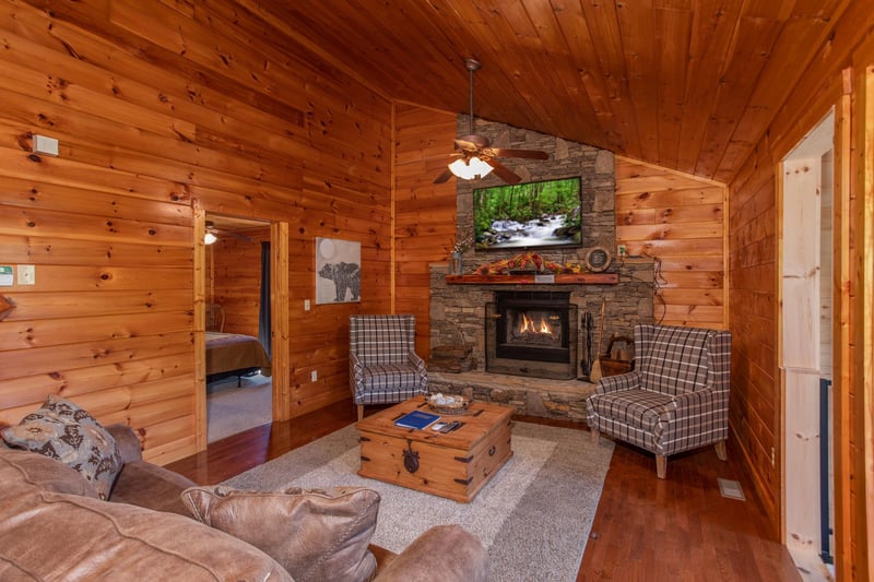 Living room with a fireplace and TV above at Cabin Fever, a 4bedroom cabin rental located in Pigeon Forge