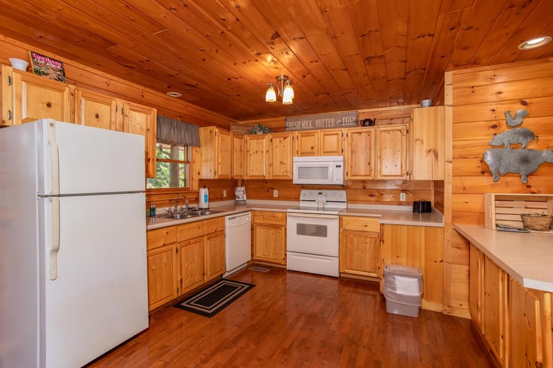 Kitchen with white appliances at Cabin Fever, a 4bedroom cabin rental located in Pigeon Forge