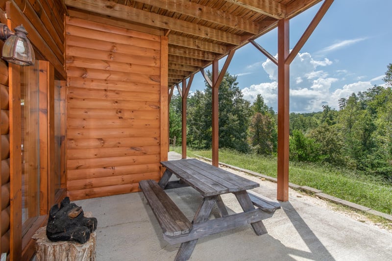 Picnic table on a patio below the deck at Cabin Fever, a 4bedroom cabin rental located in Pigeon Forge