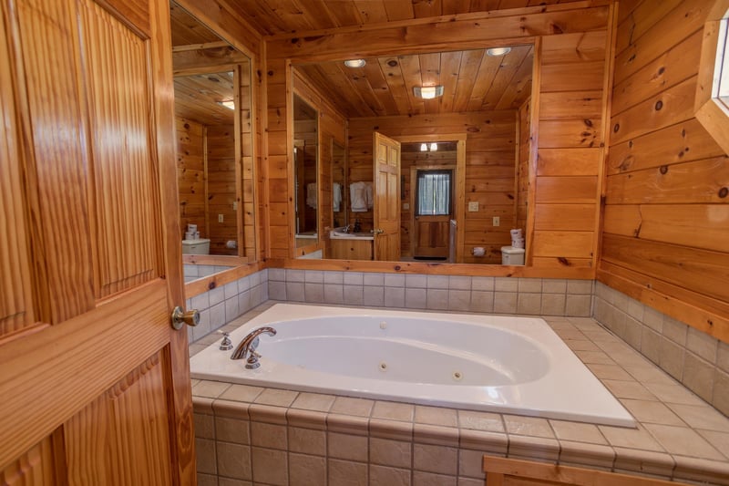 Jacuzzi tub with a mirrored surround at Cabin Fever, a 4bedroom cabin rental located in Pigeon Forge