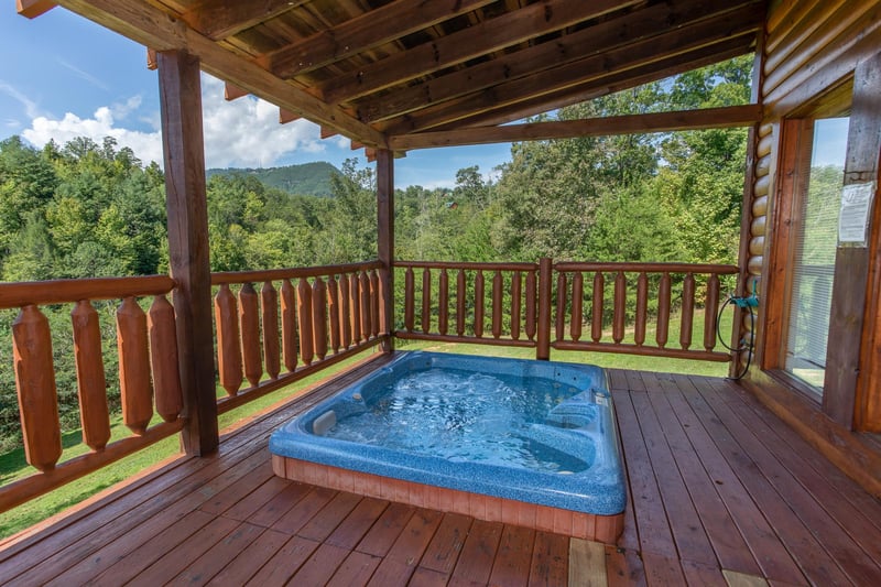 Hot tub on a covered deck at Cabin Fever, a 4bedroom cabin rental located in Pigeon Forge