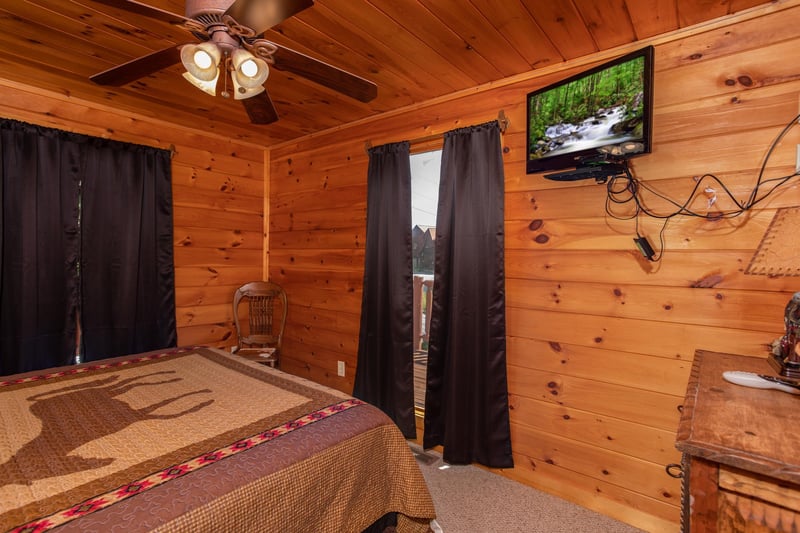 Bedroom with a dresser and wall mounted television at Cabin Fever, a 4bedroom cabin rental located in Pigeon Forge