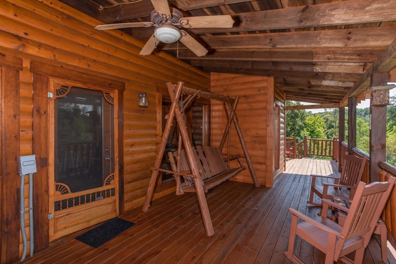 Log porch swing on a covered deck at Cabin Fever, a 4bedroom cabin rental located in Pigeon Forge