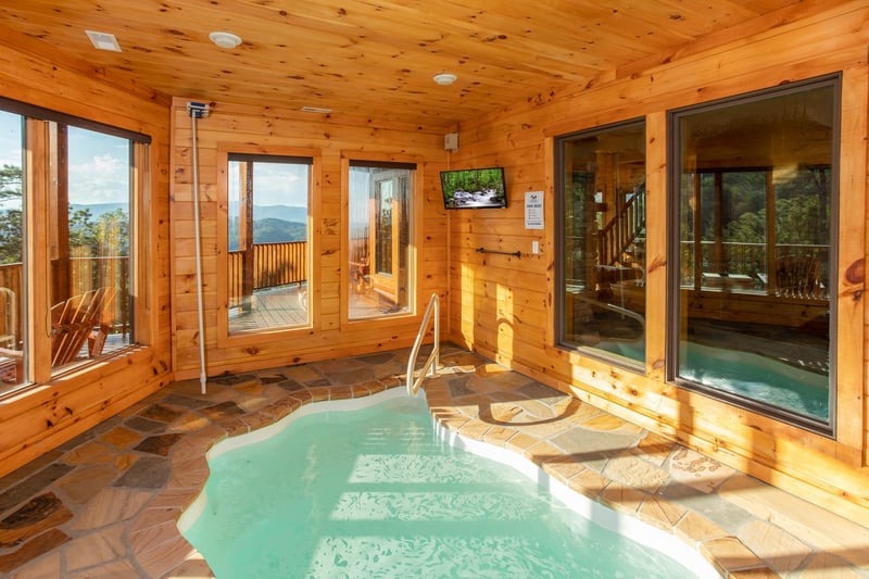 Indoor pool room with a TV at Four Seasons Palace, a 5bedroom cabin rental located in Pigeon Forge