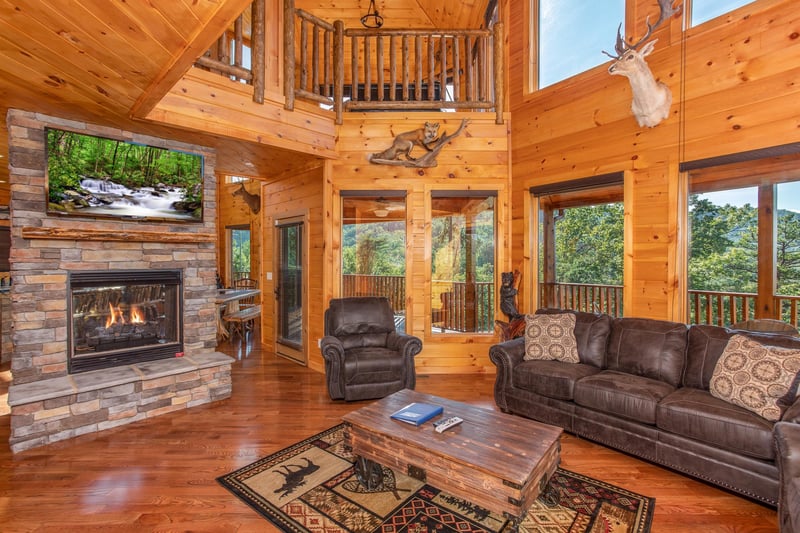 Living room with a stone fireplace and television at Four Seasons Palace, a 5bedroom cabin rental located in Pigeon Forge