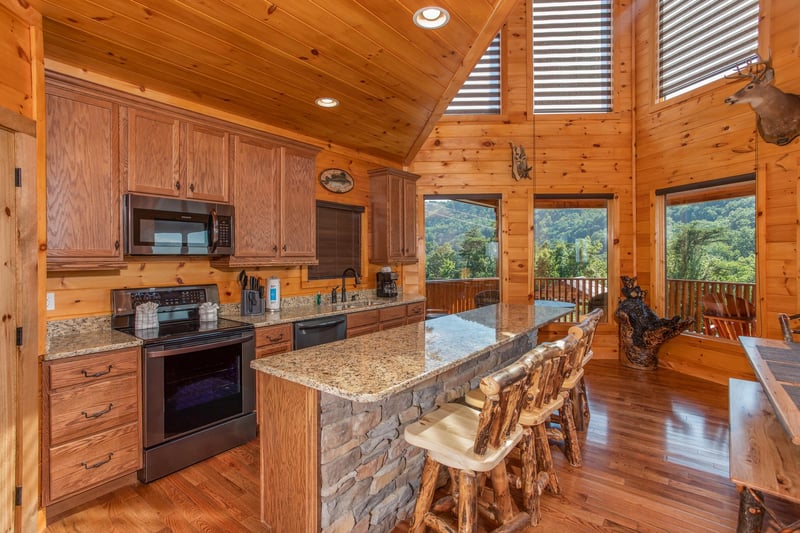 Kitchen with stainless appliances and counter seating for four at Four Seasons Palace, a 5bedroom cabin rental located in Pigeon Forge