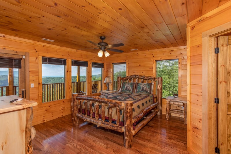 Bedroom with a log bed and deck access at Four Seasons Palace, a 5bedroom cabin rental located in Pigeon Forge