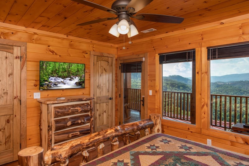 Bedroom with a TV, dresser, deck access, and mountain views at Four Seasons Palace, a 5bedroom cabin rental located in Pigeon Forge