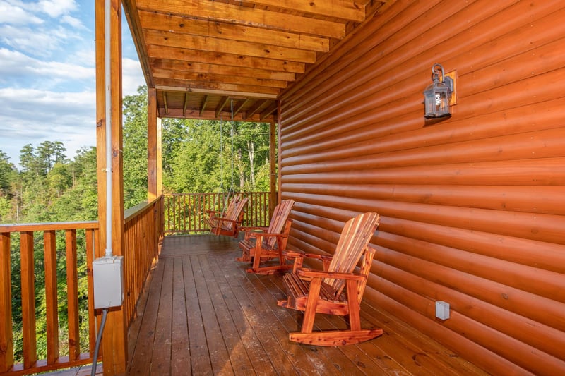 Deck rockers in a row on a covered porch at Four Seasons Palace, a 5bedroom cabin rental located in Pigeon Forge