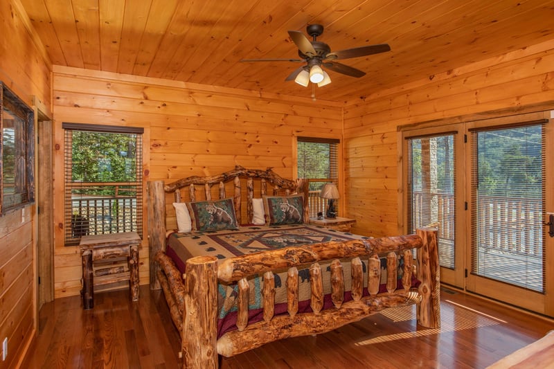 Bedroom with a log bed and deck access at Four Seasons Palace, a 5bedroom cabin rental located in Pigeon Forge