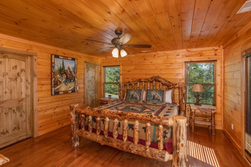 Bedroom with a kingsized log bed at Four Seasons Palace, a 5bedroom cabin rental located in Pigeon Forge