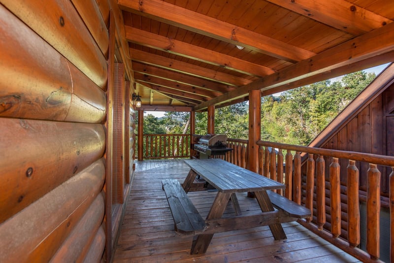 Picnic table on a covered deck at Bears Eye View, a 2bedroom cabin rental located in Pigeon Forge