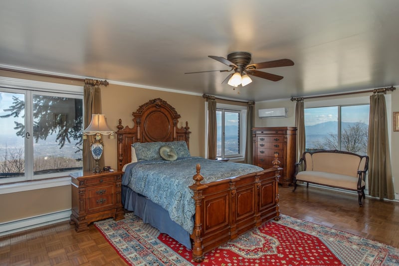 Bedroom with a bed, nightstand, chest of drawers, and sitting area at Best View Ever A 5 bedroom cabin rental in Pigeon Forge