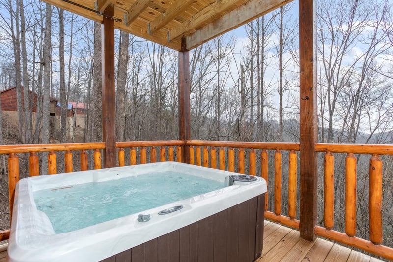 Hot tub on a covered deck at Happy Bears Hideaway, a 2 bedroom cabin rental located in Gatlinburg