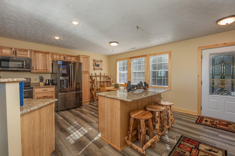 Kitchen with granite counters, stainless appliances, and a breakfast bar at Le Bear Chalet, a 7 bedroom cabin rental located in Gatlinburg