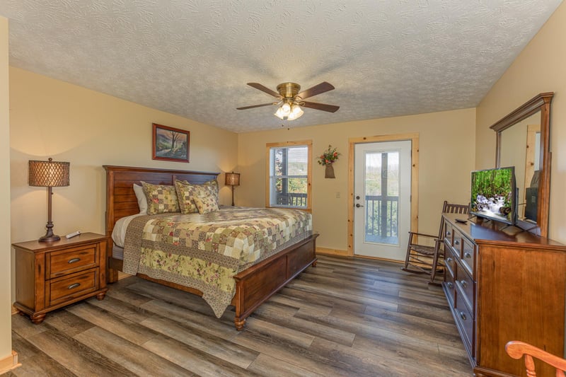 Bedroom with bed, two night stands and lamps, a dresser, and TV at Le Bear Chalet, a 7 bedroom cabin rental located in Gatlinburg