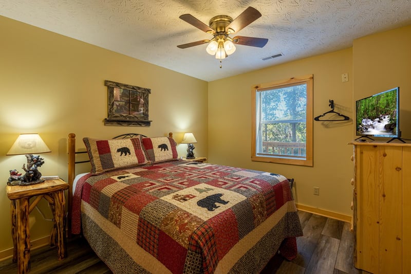 Bedroom with two night stands, lamps, dresser, and TV at Le Bear Chalet, a 7 bedroom cabin rental located in Gatlinburg