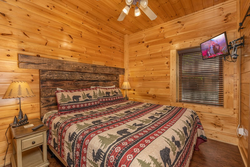 King bedroom with night stand and tv at Loving Every Minute, a 5 bedroom cabin rental located in Pigeon Forge