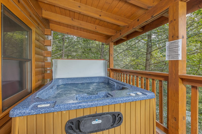 Hot tub on a covered deck at Cubs Crossing, a 3 bedroom cabin rental located in Gatlinburg
