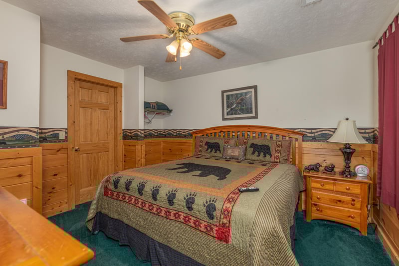King bed, night stand, and a lamp in a bedroom at Cubs Crossing, a 3 bedroom cabin rental located in Gatlinburg