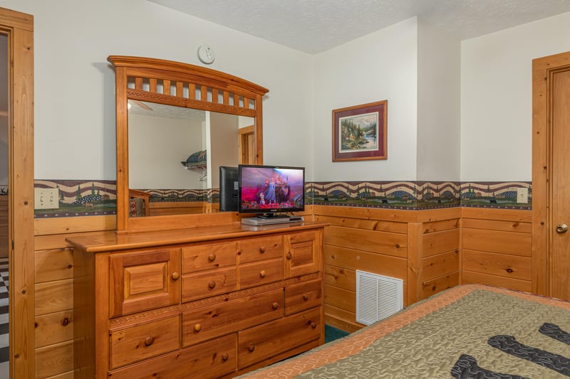 Dresser, mirror, and TV in a bedroom at Cubs Crossing, a 3 bedroom cabin rental located in Gatlinburg