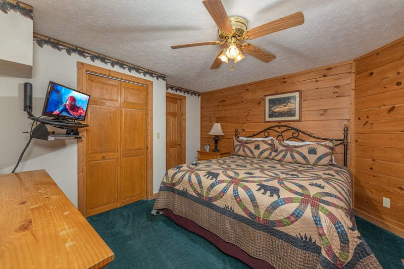 King bed, night stand, lamp, and TV in a bedroom at Cubs Crossing, a 3 bedroom cabin rental located in Gatlinburg
