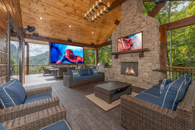 Deck seating area with an outdoor theater projector at Black Bears  Biscuits Lodge, a 6 bedroom cabin rental located in Pigeon Forge