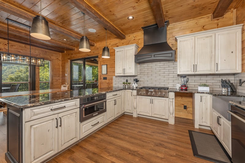 Kitchen with white cabinets and black appliances at Black Bears  Biscuits Lodge, a 6 bedroom cabin rental located in Pigeon Forge