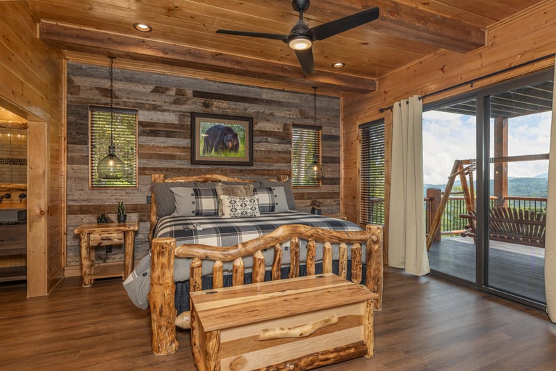 Bedroom with a log bed, night stands, a chest, and deck access at Black Bears  Biscuits Lodge, a 6 bedroom cabin rental located in Pigeon Forge