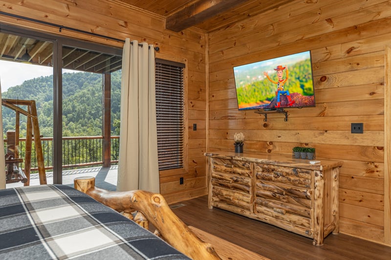 Dresser, TV, and deck access in a bedroom at Black Bears  Biscuits Lodge, a 6 bedroom cabin rental located in Pigeon Forge