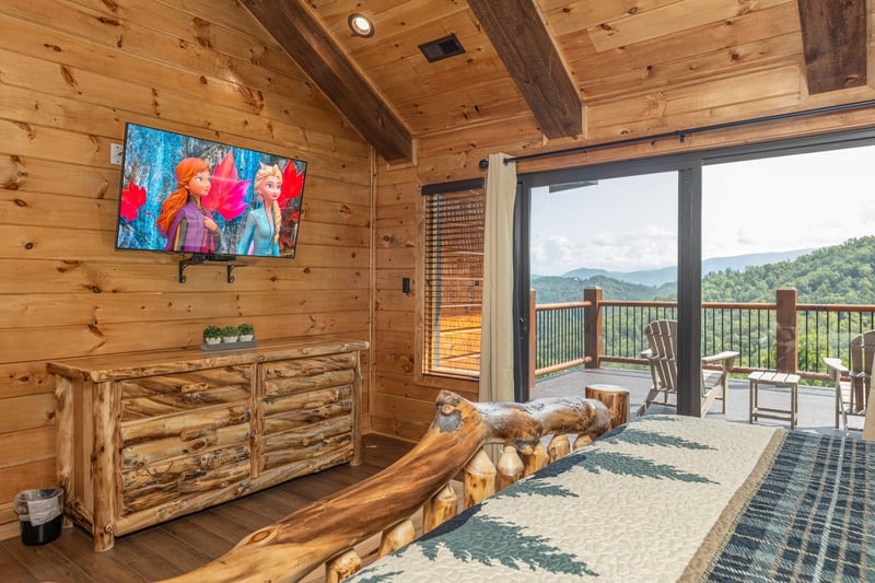 Dresser, TV, and deck access in a bedroom at Black Bears  Biscuits Lodge, a 6 bedroom cabin rental located in Pigeon Forge