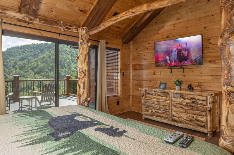 Dresser, TV, and deck access in a bedroom at Black Bears  Biscuits Lodge, a 6 bedroom cabin rental located in Pigeon Forge