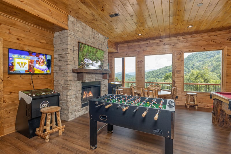 Game room with foosball, Golden Tee, fireplace, and TV at Black Bears  Biscuits Lodge, a 6 bedroom cabin rental located in Pigeon Forge