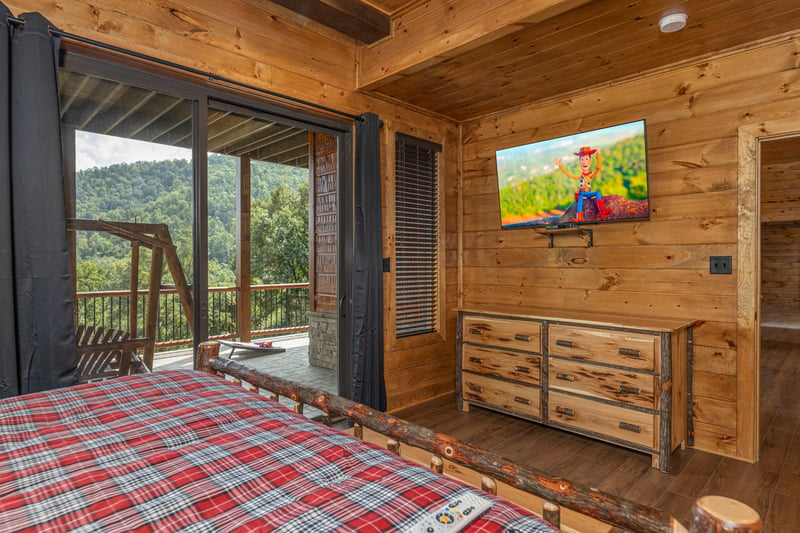 Dresser, TV, and deck access at Black Bears  Biscuits Lodge, a 6 bedroom cabin rental located in Pigeon Forge